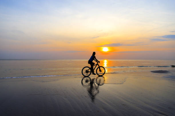 istock Woman with mountain bike on beach 929949896