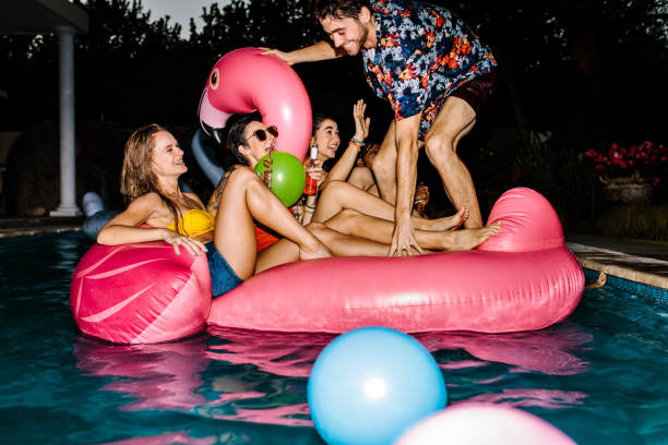 istock Group of happy friends partying in a swimming pool 929952496