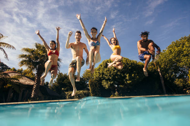 istock Friends having fun at holiday resort pool 929952530
