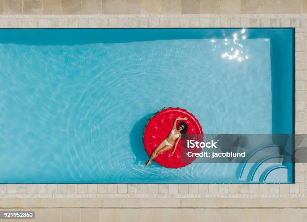 Young Woman Floating On Inflatable Mattress In Pool Stock Photo - Download Image Now