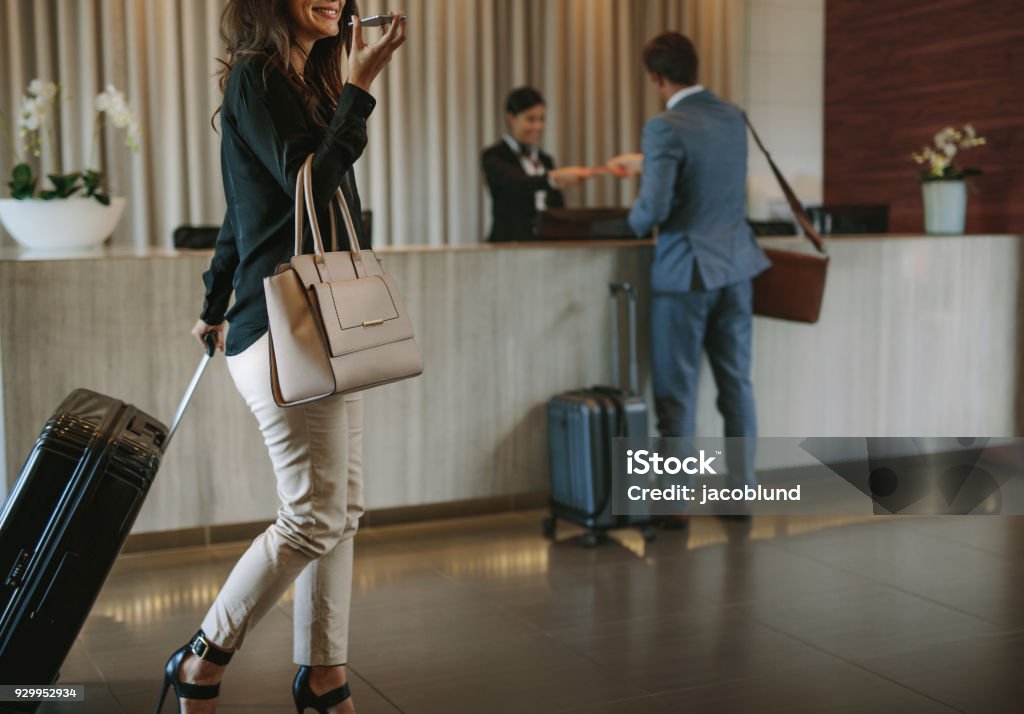 Frau, die Ankunft in der Hotellobby mit Koffer - Lizenzfrei Hotel Stock-Foto