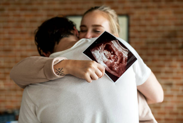 paar mit baby ultraschall foto weiß - umarmen fotos stock-fotos und bilder