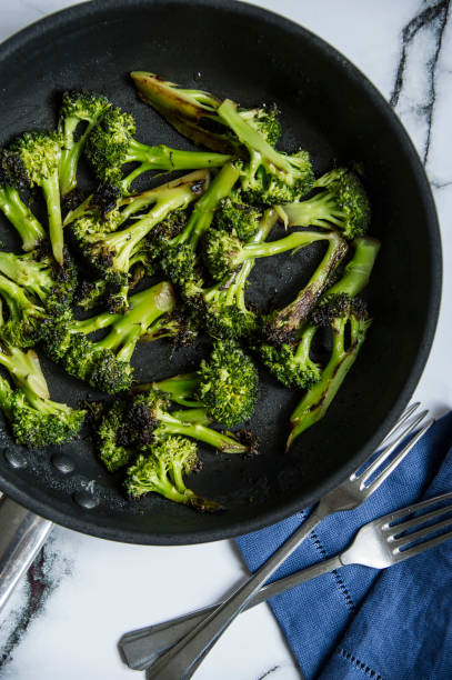 Simple diet meal, fried broccoli roses in a frying pan. stock photo