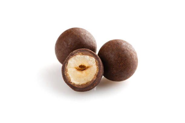 istock Heap of sugared hazelnuts dragees in chocolate isolated on white background 929956584
