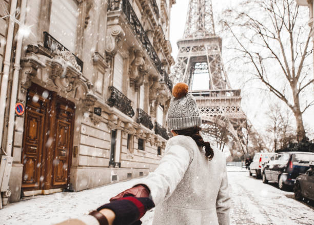 frau zu fuß zum eiffelturm mit schnee - paris stock-fotos und bilder