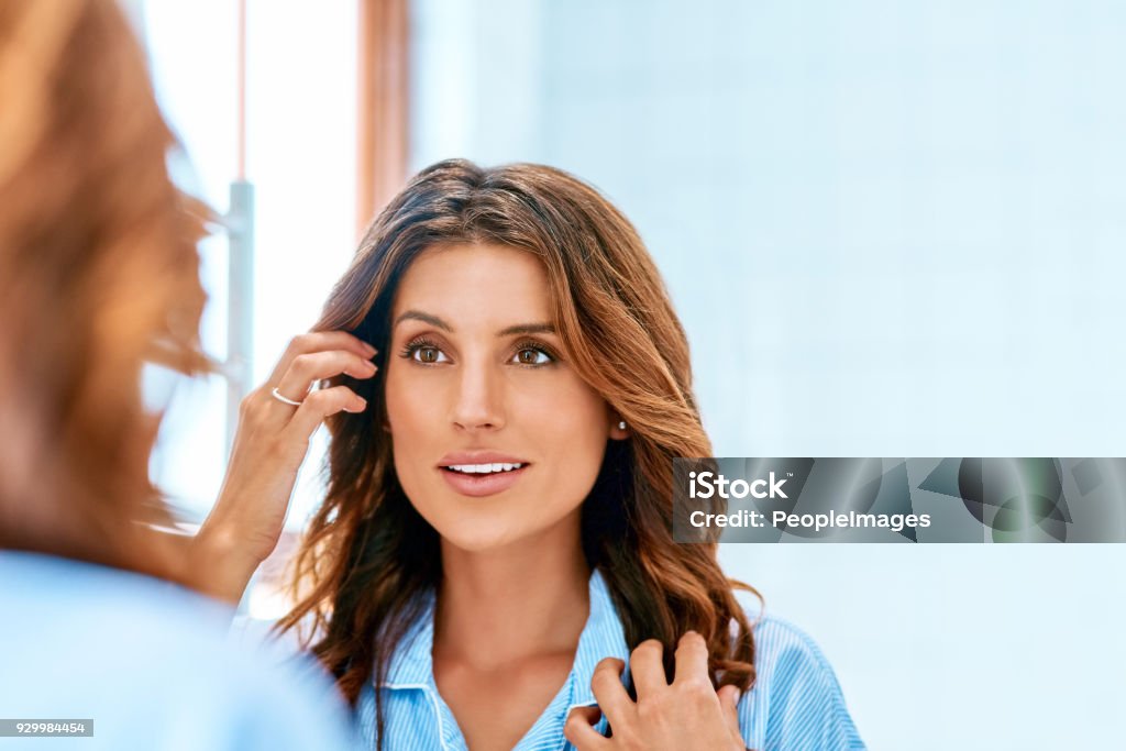 Looking gorgeous and ready to take on the day Cropped shot of a beautiful young woman grooming herself at home Mirror - Object Stock Photo