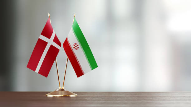 istock Danish And Iranian Flag Pair On A Desk Over Defocused Background 929987444