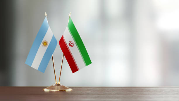 istock Argentinian And Iranian Flag Pair On A Desk Over Defocused Background 929989520