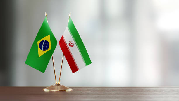 istock Brazilian And Iranian Flag Pair On A Desk Over Defocused Background 929989892