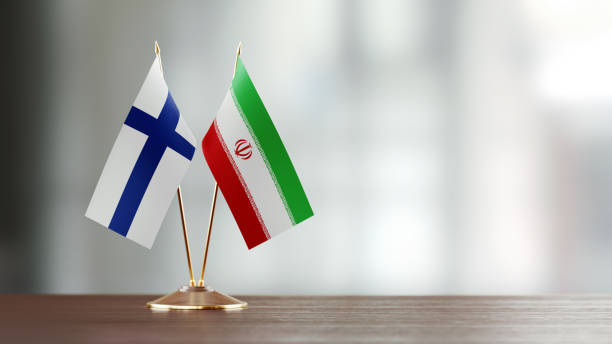 istock Finnish And Iranian Flag Pair On A Desk Over Defocused Background 929990214