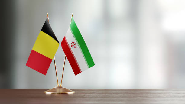 istock Belgian And Iranian Flag Pair On A Desk Over Defocused Background 929990312