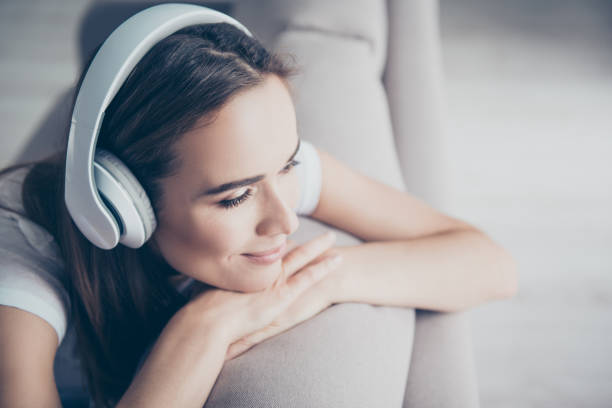 chillout, satisfaction, therapy, wellness, leisure, lifestyle mode. charmed adorable brown haired adorable model enjoying to the stereo sound in big modern ear phones in a room, nice break, good-day - music listening women relaxation imagens e fotografias de stock