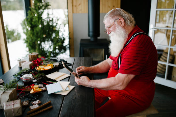 istock Santa Claus using digital tablet in his log cabin 929997268