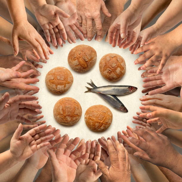 istock Five small barley loaves and two small fish for many hands 929998256