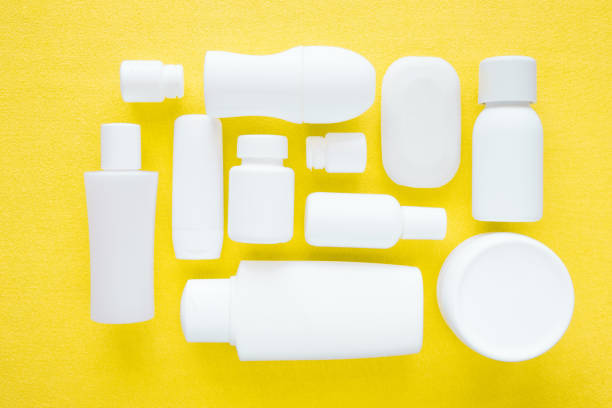Different, white beauty toiletries on yellow towel. Mock up for special offers as advertising. Cares about men's, women's and kids hair and body skin in summer. Empty place for logo. Flat lay. artículos de tocador de belleza diferente, blanco sobre paño amarillo. se burlan para ofertas especiales de publicidad. se preocupa por los hombres, mujeres y niños de piel cabello y cuerpo en verano. lugar vacío para el logo. la endecha plana.
