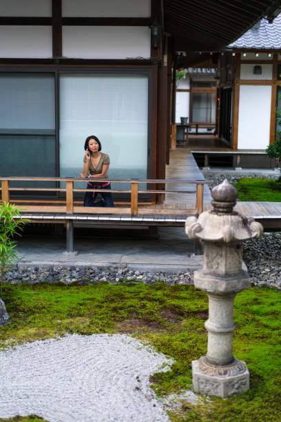 widok kobieta mówi przez telefon komórkowy w ogrodzie zen świątyni chion-ji w kioto, japonia - zen like women temple meditating zdjęcia i obrazy z banku zdjęć