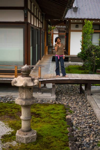 vue de femme, parler au téléphone mobile dans le zen jardin de chion-ji à kyoto, japon - zen like women temple meditating photos et images de collection