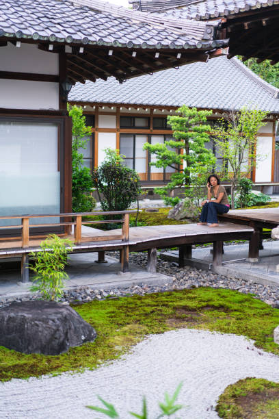 vue de femme, parler au téléphone mobile dans le zen jardin de chion-ji à kyoto, japon - zen like women temple meditating photos et images de collection