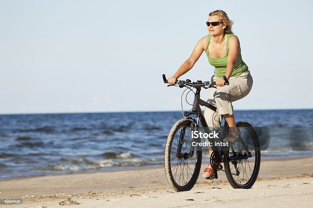 Mulher andando de bicicleta na praia - Foto de stock de Ciclismo royalty-free