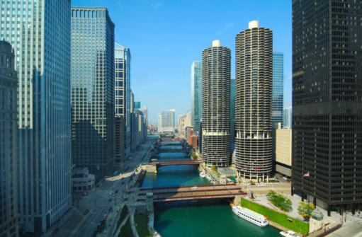 View of elevated train track with el train crossing Lake Street and the Chicago River in summer