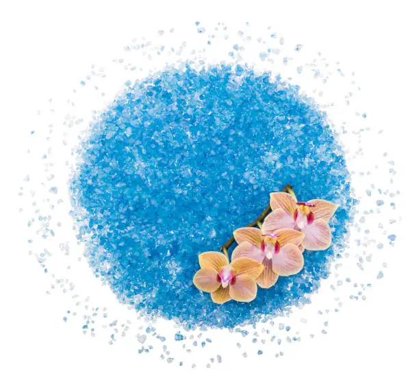 Scattered blue bath salt with orchid flower