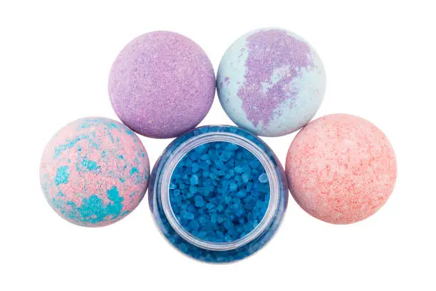 Spotted bath bombs and open bottle with blue sea salt, top view