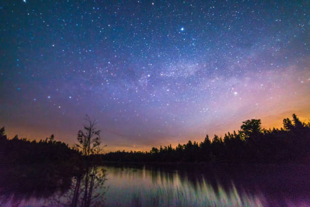 夜天の川、星と夜空にまだ川にカラフルな月の出 - northern lake ストックフォトと画像