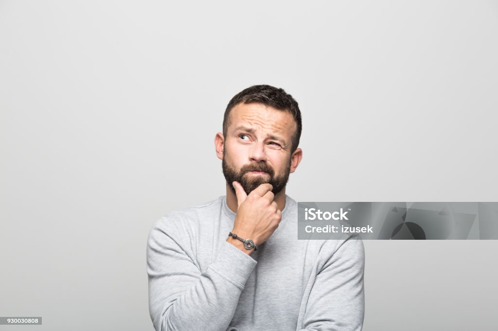 Porträt von besorgt bärtiger junger Mann mit Hand am Kinn nachschlagen - Lizenzfrei Betrachtung Stock-Foto