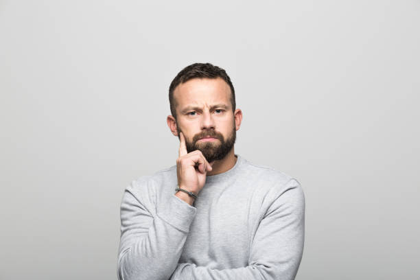istock Portrait of pensive bearded young man, grey background 930034244