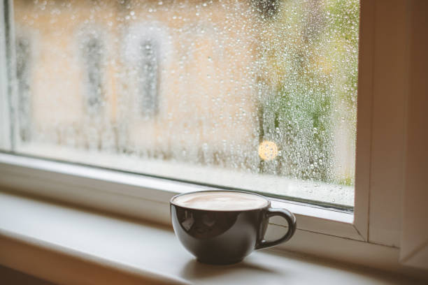 Café en un alféizar de la ventana en un día lluvioso. - foto de stock