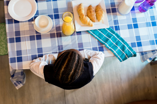 Photo from above of a young girl eating breakfast