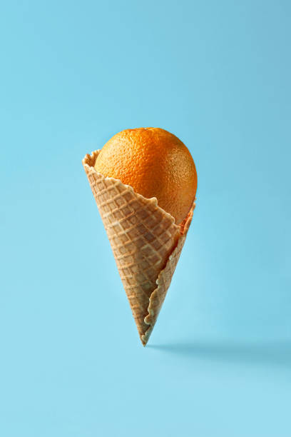 istock Orange like ice cream lies in waffle cone on a light blue background. Pattern 930059456