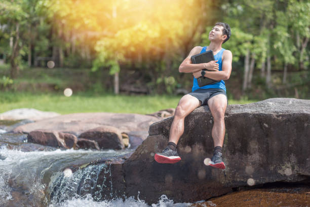 istock Hiker backpack travel and online working with his phone at  waterfall  the forest. 930063412