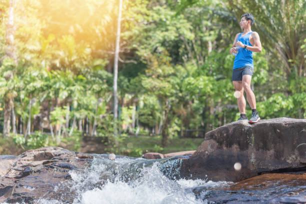istock Young asian man in a yoga pose at the waterfall 930067468