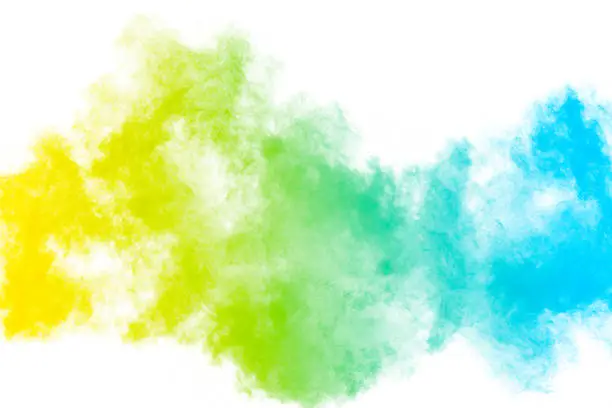 Photo of The explosion of color powder. Beautiful powder fly away. The cloud of glowing color powder on white background