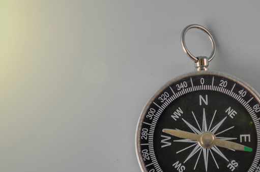 compass on gray background concept - direction motion top view\