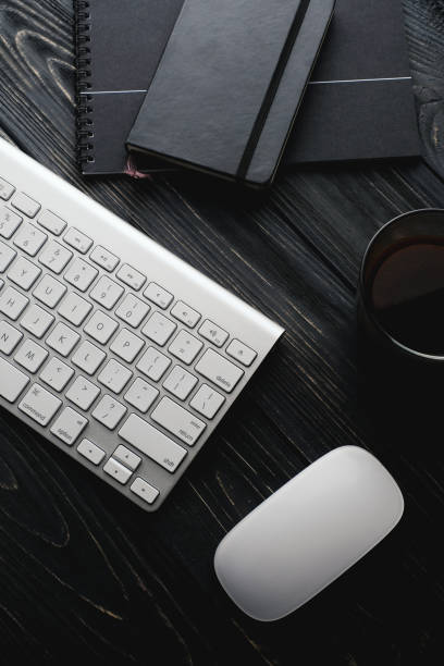 istock Modern dark surface wooden office desk table with computer and cup of coffee. Hero Header Concept with Copy space. 930079268
