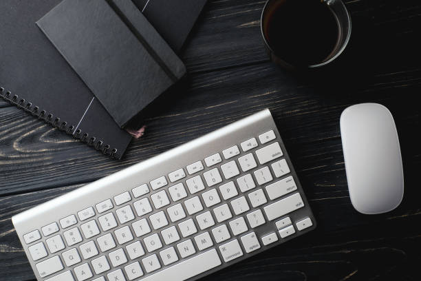istock Modern dark surface wooden office desk table with computer and cup of coffee. Hero Header Concept with Copy space. 930079336