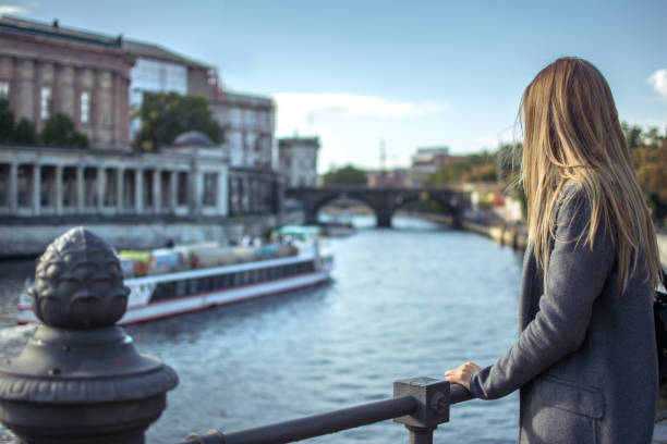 istock Back view of young woman looking over Spree river in Berlin, Germany. 930082174