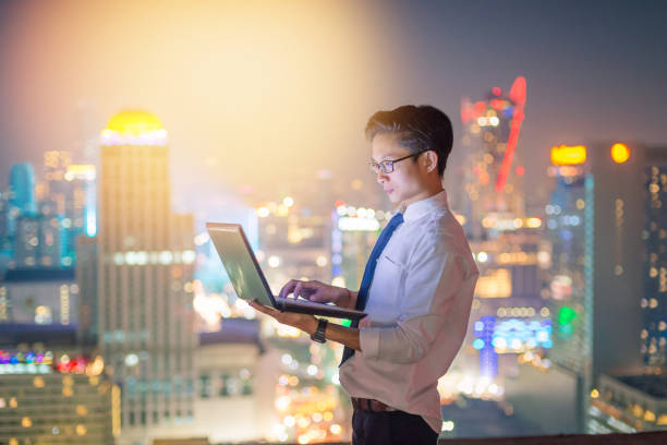 istock Business using laptop and digital tablet at skyscaper background 930082196