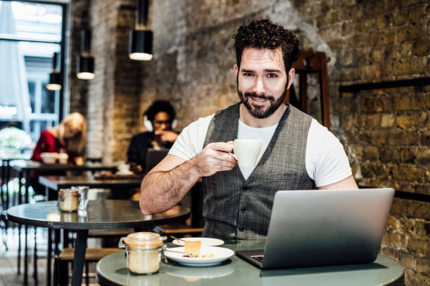 istock Mid adult man with espresso using laptop in cafe 930090000