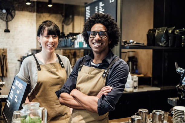 istock Two colleagues working in coffee shop smiling towards camera 930090058