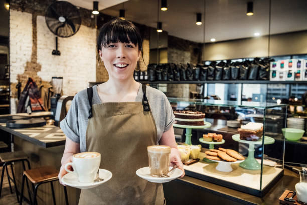 Young woman working in cafe with hot drinks
