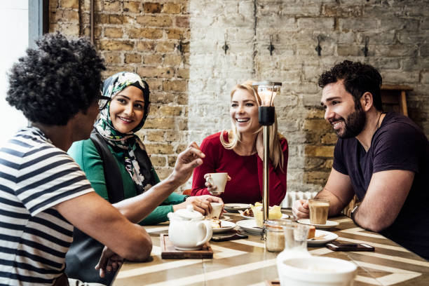 istock Group of friends sitting in cafe smiling and talking 930090108