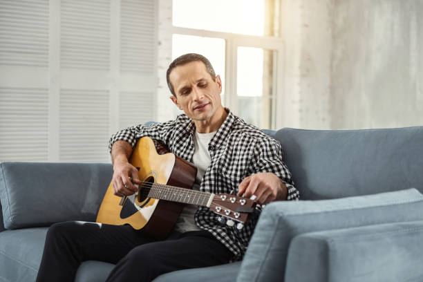 istock Content man relaxing and playing the guitar 930091070