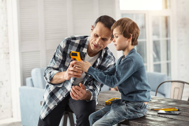 istock Concentrated daddy showing his instruments to his son 930095068