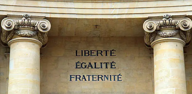 Famous political words in French, saying Liberty, Equality, and Fraternity on a wall, flanked by columns; the motto of the French Revolution.  