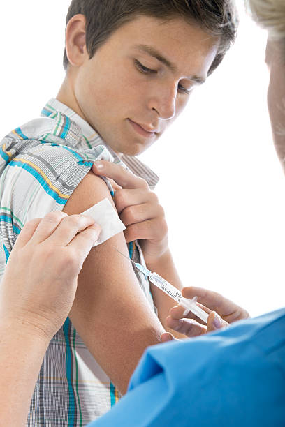 Young man getting a needle injection teenager getting a swine flu injection. injecting flu virus vaccination child stock pictures, royalty-free photos & images