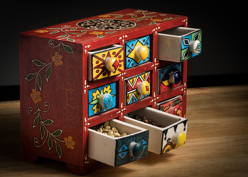 Small colorful painted box with drawers for spices, open drawers