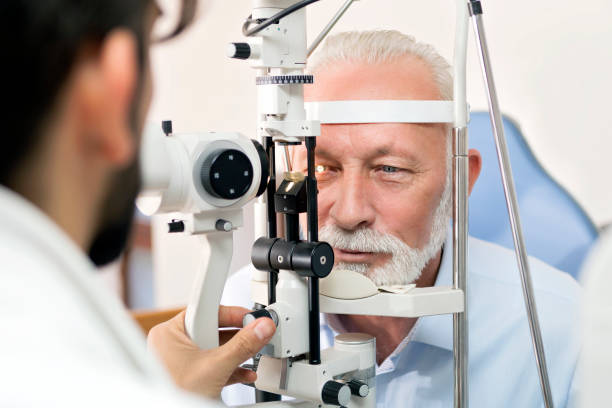 optometrista control a senior hombre con máquina de optometría - retina display fotografías e imágenes de stock